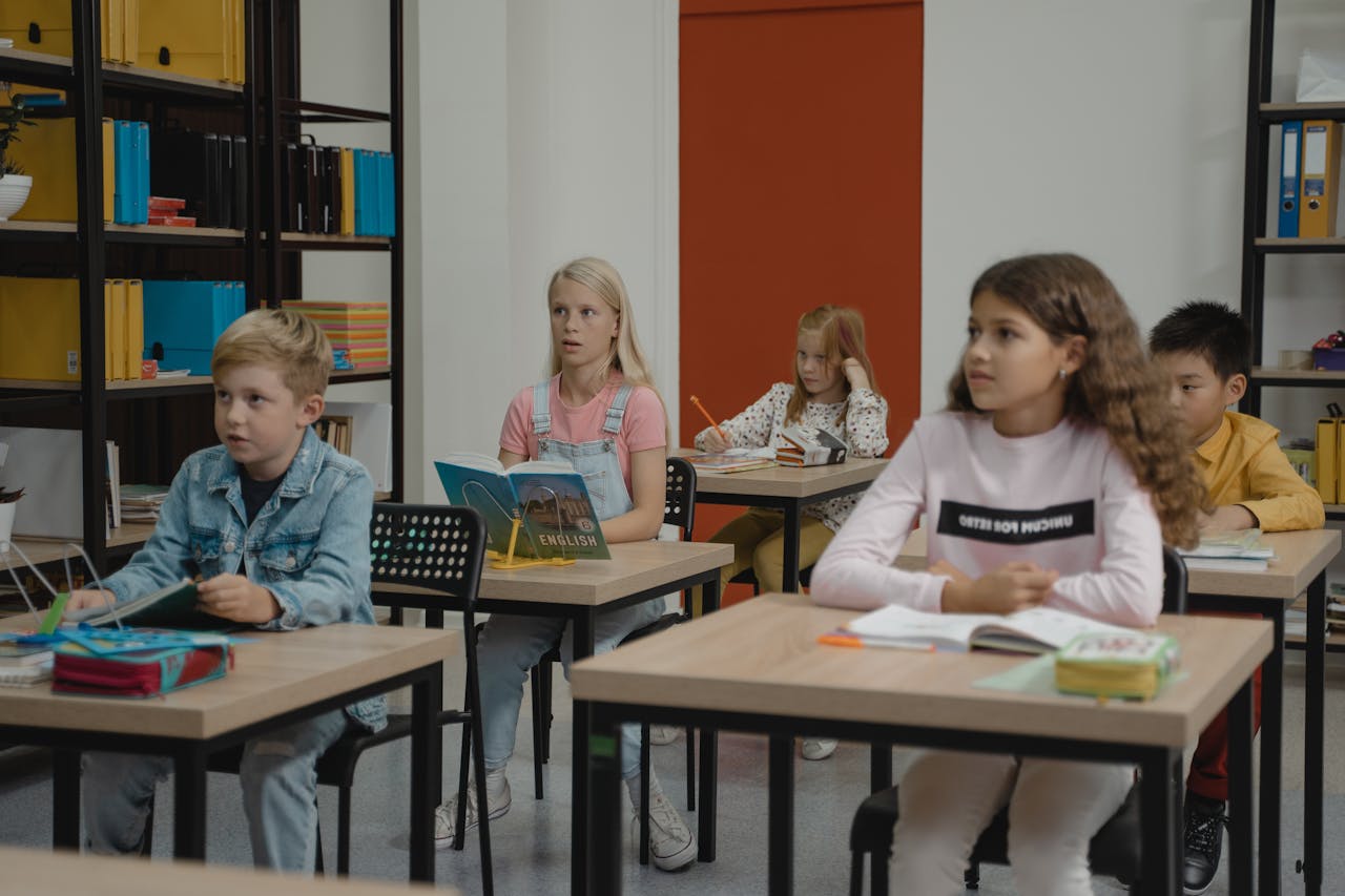 Children attentively studying in a colorful classroom setting, focused and engaged.